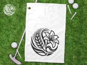 Poly linen sublimation golf towel with Saskatchewan Prairie Lily design and waffle weave texture displayed on grass with golf equipment